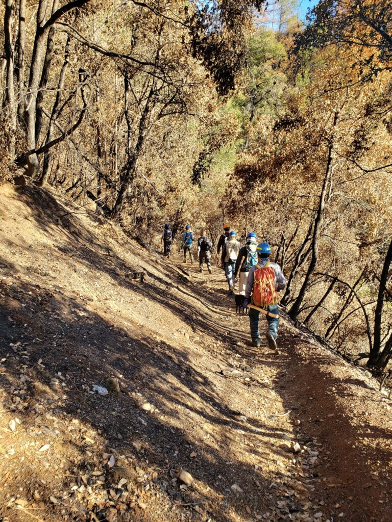 Volunteer trail workers hiking down the burned portion in El Dorado Canyon